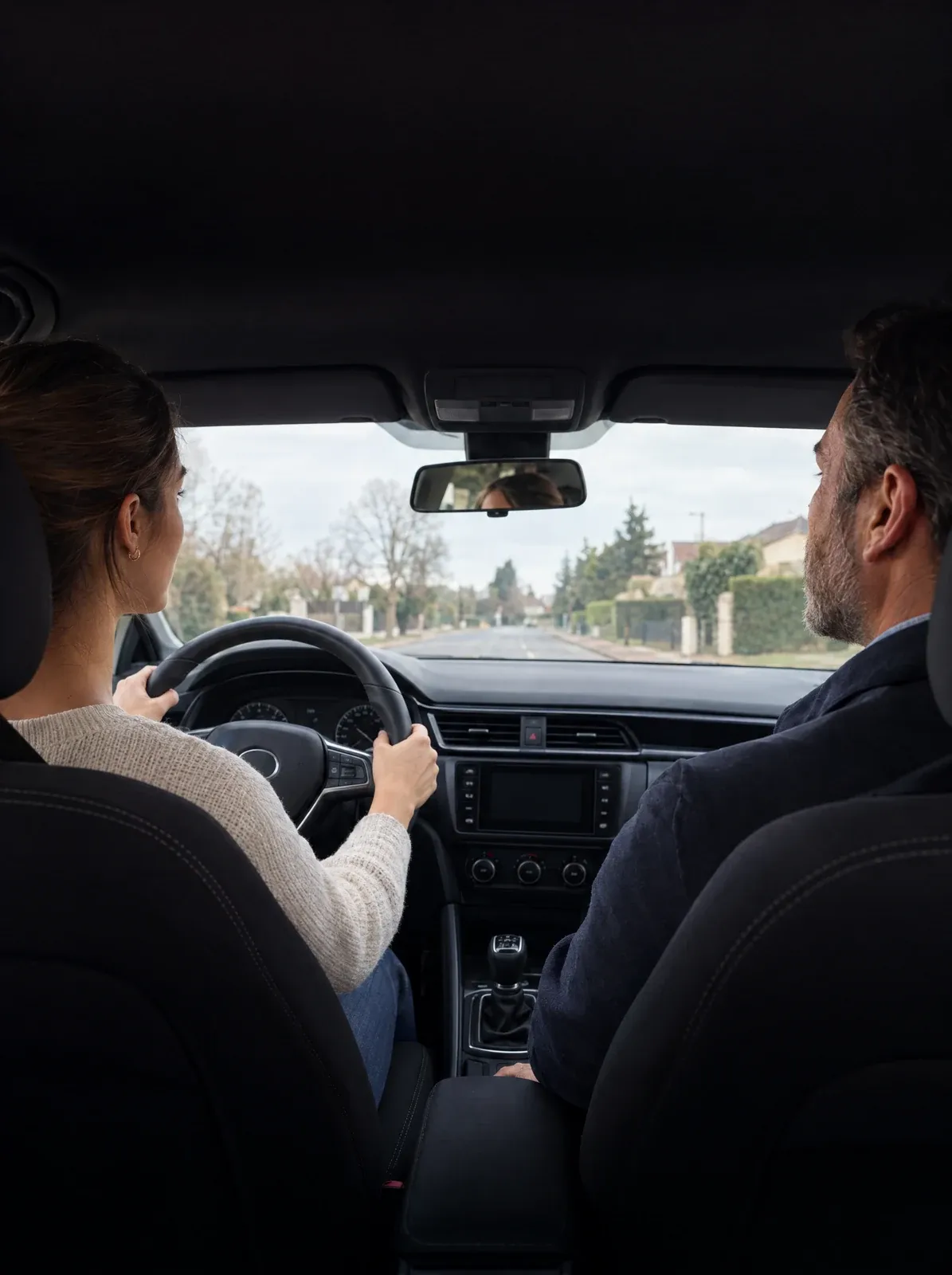 Leçon de conduite en auto-école : une élève au volant et son moniteur sur le siège passager